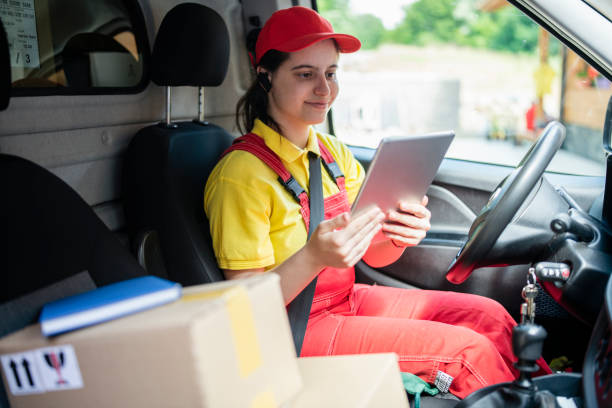 istock Female delivery worker in the delivery truck using digital tablet. 1494857610