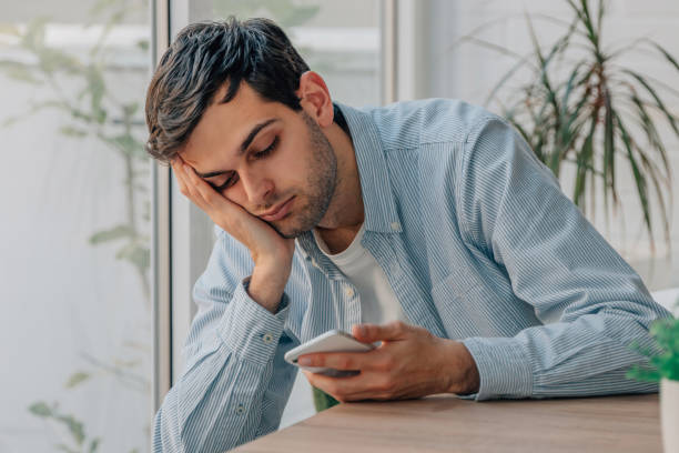 istock young man at home bored looking at mobile phone 1494859365