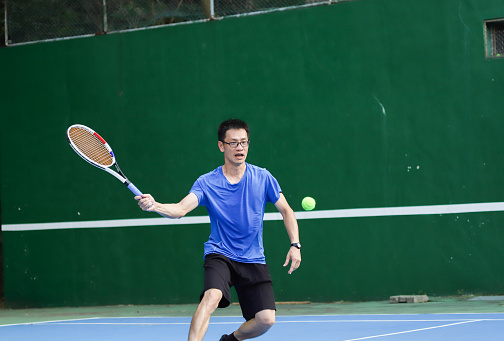 asian tennis player is playing on tennis court