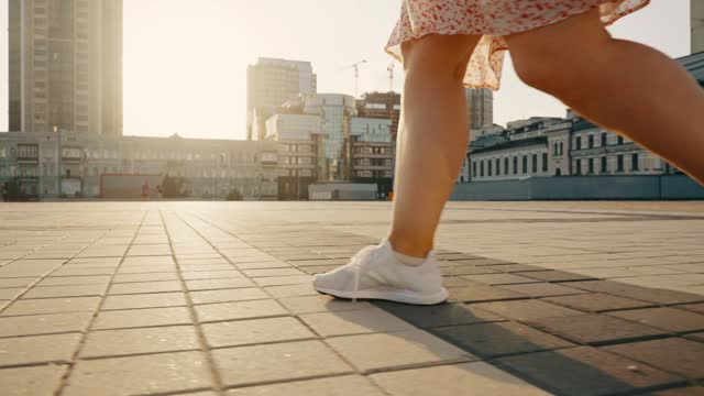 Close-up of the girl's legs starting to move along the street.