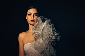 Studio shot of young beautiful woman wearing amazing dress with flower