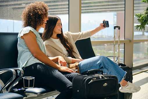 Two young women travelers in a public airport.