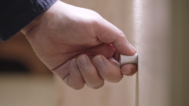 Extreme close-up of male hand pulling and pushing a wooden drawer