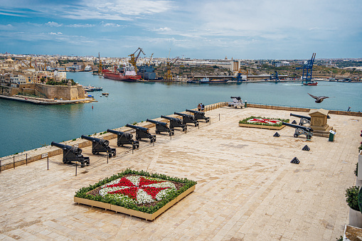 View to Grand Harbour and medieval cannons of saluting battery from Valetta wall, Malta