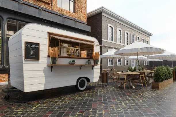 Photo of Close-up View Of Ice Cream Van With Wooden Tables, Chairs And Parasols