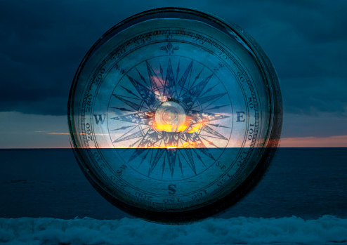Compass on the Background of Ocean Waves. Close up of Antique Compass. Compass with Natural Blur Background. Travel Concept.