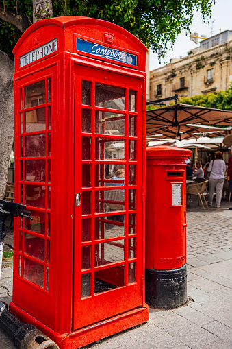 Old-fashioned British traditional red telephone box in the street at Valletta, Malta
