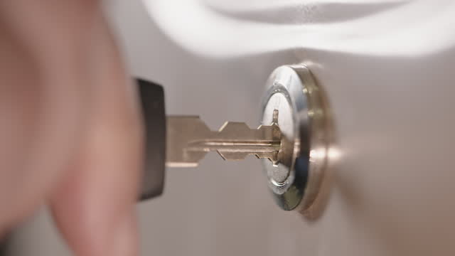 Extreme close-up of metal lock of filling cabinet being unlocked, pull opened, pushed closed and locked again