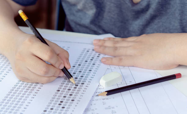 istock Students hand holding pencil writing selected choice on answer sheets and Mathematics question sheets. students testing doing examination. school exam 1494879709
