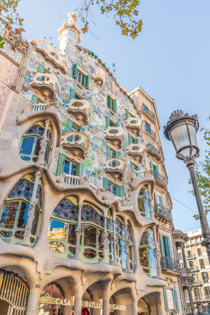 straßenlaterne vor dem hintergrund des casa batlló-gebäudes in barcelona im herbst, vertikal - barcelona antonio gaudi casa battlo spain stock-fotos und bilder