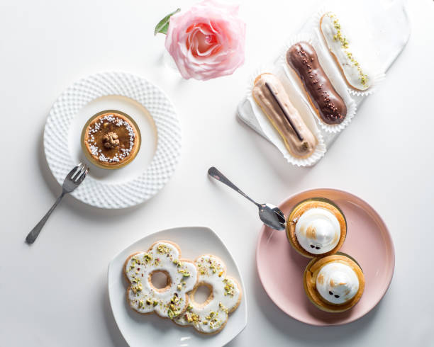 istock Various desserts and cakes, eclairs on the table. Top view 1494886454
