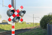 Railway signal light - semaphore and barrier. Railway crossing. Warning road sign about the proximity of a railway crossing.