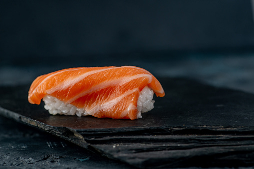 Sashimi with salmon on a dark background. Asian cuisine