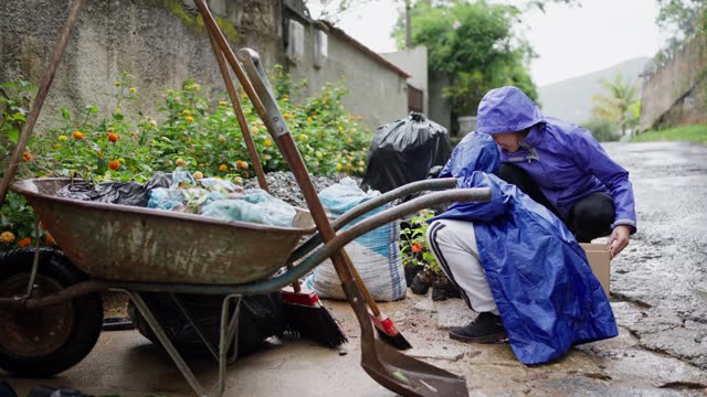 Women preparing seedlings for planting while gardening in the rain