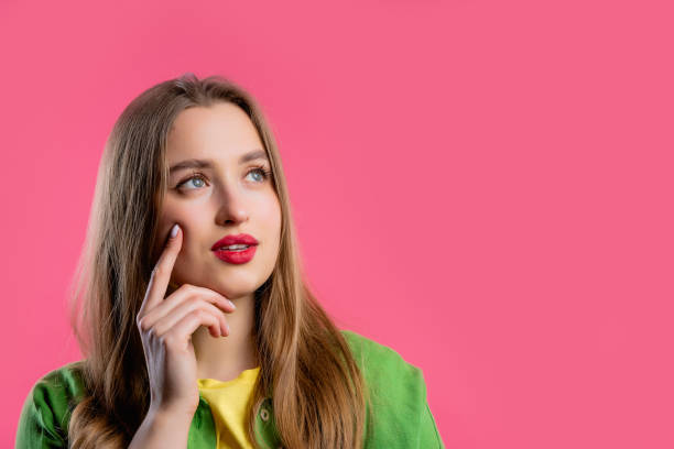 istock Thinking around woman on pink background. Puzzled lady looking for answer. 1494890117