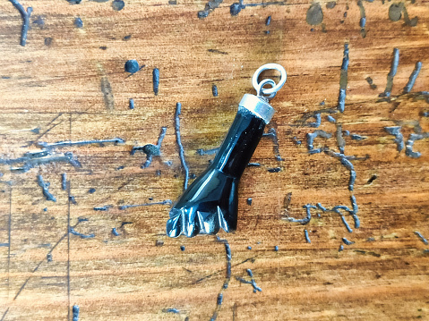 Amuleto de mano con el puño cerrado hecho a mano en azabache o ámbar negro sobre una mesa antigua, Villaviciosa, Asturias, España photo