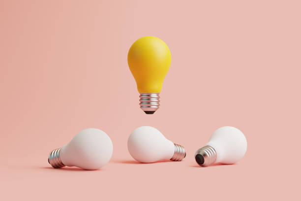 istock Glowing light bulb flies among white light bulbs on a pastel background 1494890611