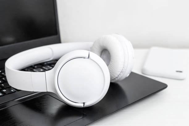 istock Laptop with bluetooth headphones and smart phone on the table. Close up. 1494893536