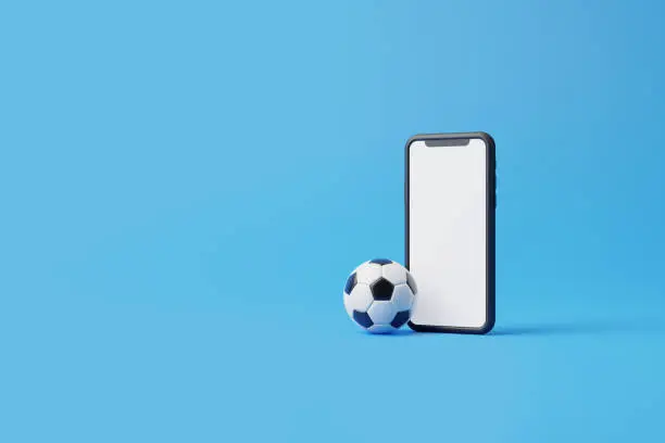 Photo of Mobile phone with a white screen and a soccer ball on a blue background with copy space