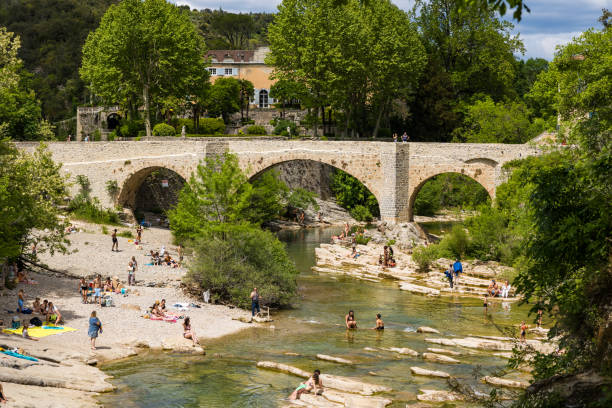 Bathers in the Vis river near Saint-Laurent-le-Minier from the waterfall