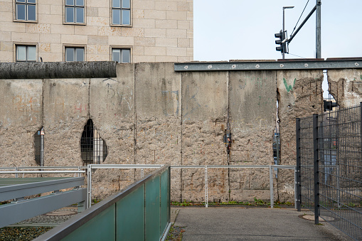 Berlin Germany on November 25, 2022: Outside the Topography of Terror museum, in Berlin, Germany, people walk along the trench and view an exhibit at remnants of the Berlin Wall.
