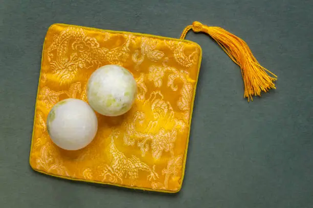 a pair of green marble Chinese medicine balls with a bag