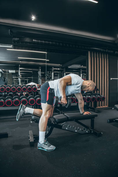 istock Young man training in gym with dumbbells 1494903004