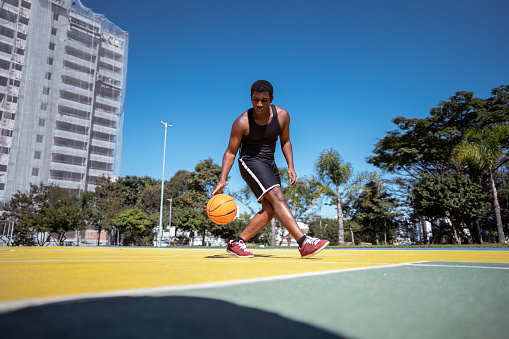 Young man playing basketball on a sport court