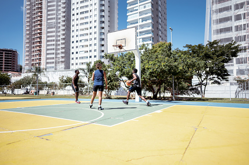 Friends playing basketball on a sport court
