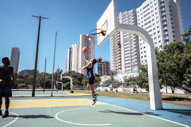 Friends playing basketball on a sport court