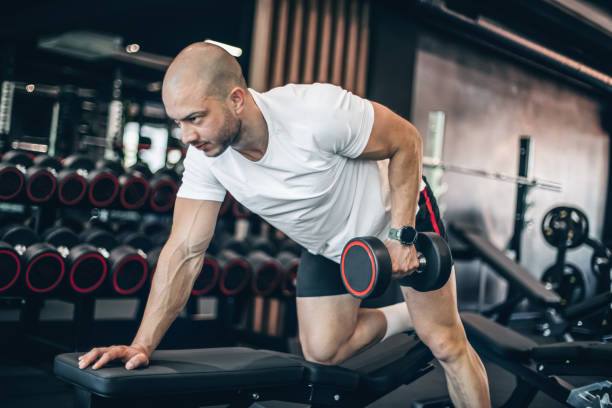istock Young man training in gym with dumbbells 1494905450