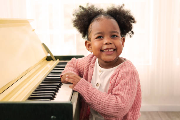 istock Kid playing piano, Daughter in piano class, Happy kid playing piano 1494906229