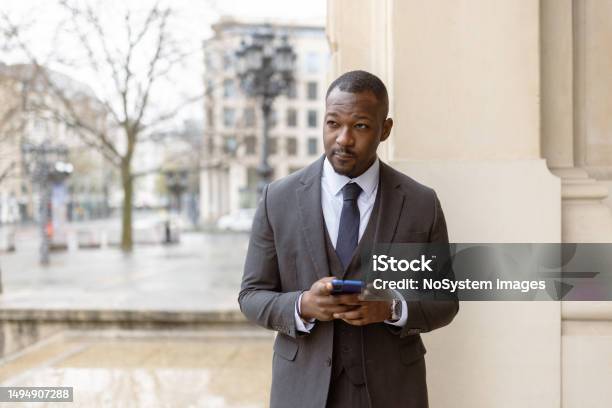 Focused Black Business Leader Staying Connected With Emails Amidst Frankfurts Financial District Stock Photo - Download Image Now
