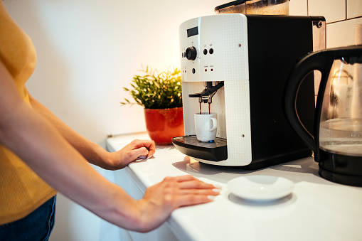 Woman use coffee machine to make coffee at home