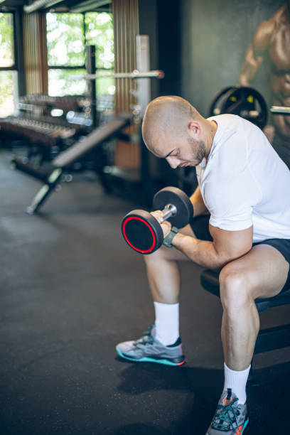 istock Young man training in gym with dumbbells 1494908533