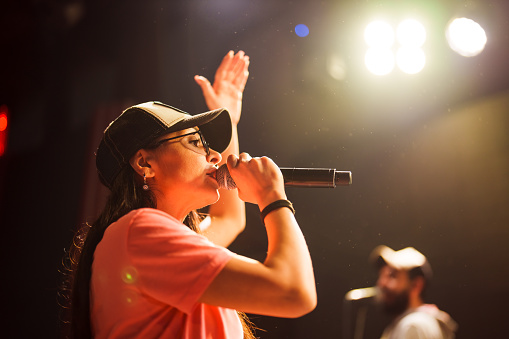 Young woman singing with the microphone