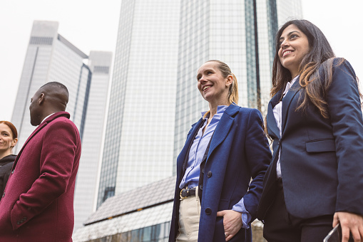 Elegant Colleagues Chat Animatedly, Eager to Attend a Meeting in the Heart of Frankfurt.
Fun fact: Frankfurt's skyline is dominated by high-rise buildings, and the city has the highest concentration of skyscrapers in Germany, symbolizing its importance as a business and financial hub.