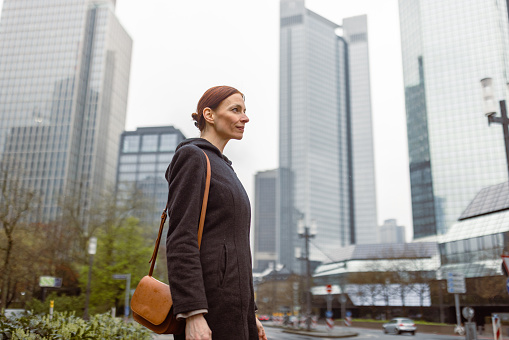 Portrait of businesswoman elegantly dressed in Frankfurt's business district. Her professional attire and confident expression exude success and determination