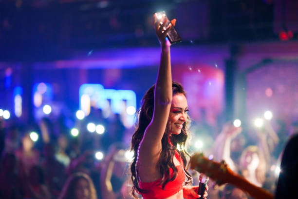 istock Musician on stage singing with microphone to crowded audience 1494910418