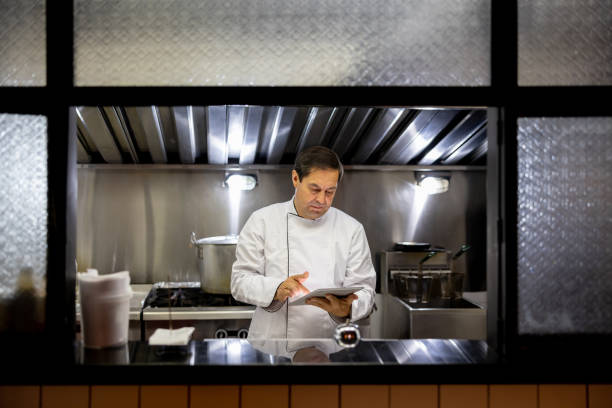 istock Chef working at a restaurant and looking at a recipe on a tablet 1494912657