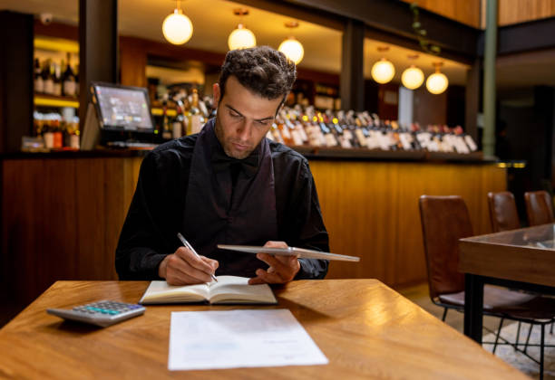 istock Business owner doing the accountancy at a restaurant after closing 1494912686