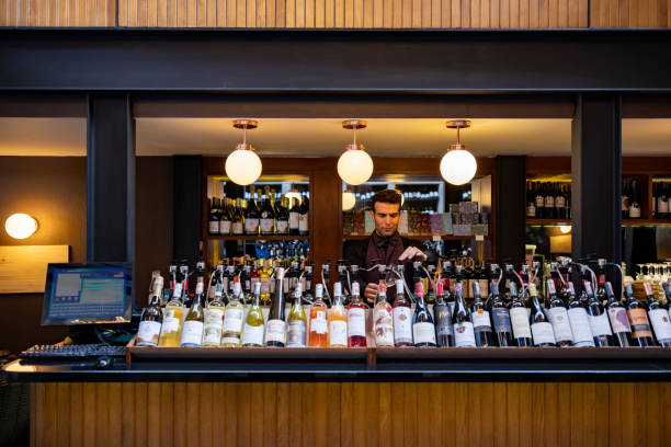Sommelier pouring a glass of wine at a winery Latin American sommelier pouring a glass of wine at a winery - wine tasting concepts wine bar counter stock pictures, royalty-free photos & images