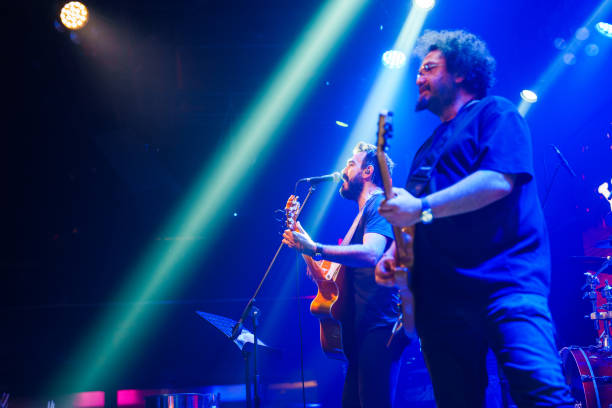istock Male singer playing guitar on stage 1494912812