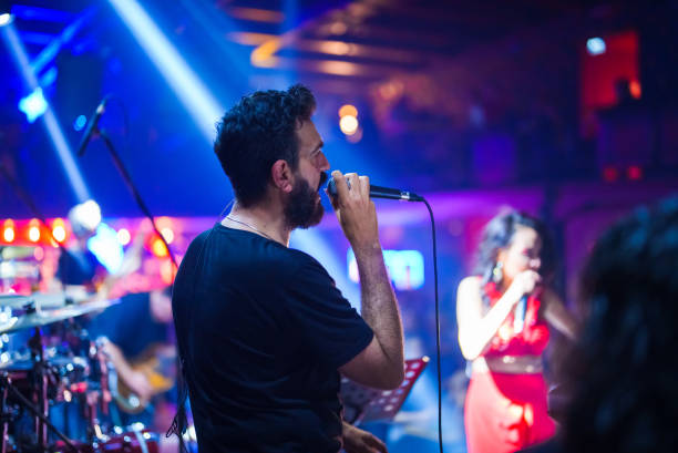 istock Male singer playing guitar on stage 1494913081
