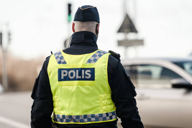 Swedish polieman blocking a road at an incident.. Gothenburg, Sweden - February 25 2023: Swedish polieman blocking a road at an incident. red white blue bike stock pictures, royalty-free photos & images
