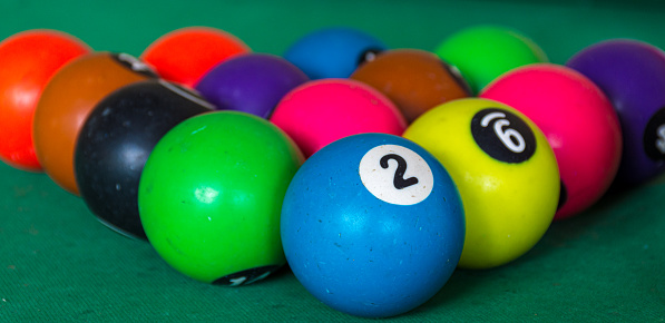 Billiard balls, pool table with balls and clubs to play billiards with green background and focus on the balls and blurred areas