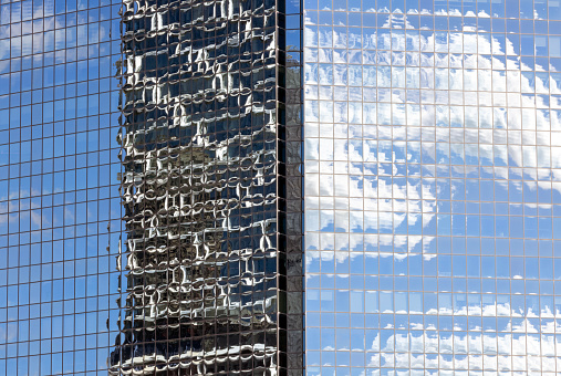 Closeup glass wall of office building with reflection of office building, abstract background with copy space, full frame horizontal composition