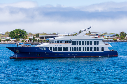 Puerto Moreno, Galapagos, Ecuador - August 21, 2022: The luxury yacht Origin, owned by Relais and Chateaux, anchored in Puerto Moreno in the Galapagos Island of Ecuador.