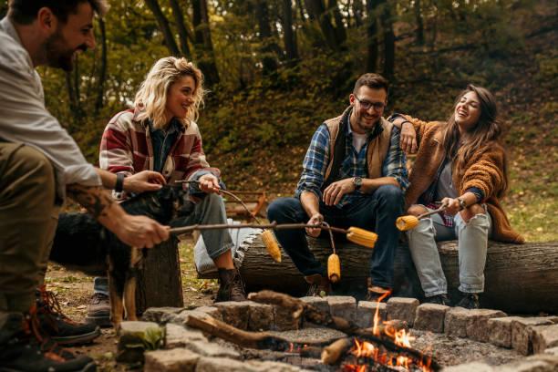 istock Multi-ethnic hipster friends on summer holidays having fun roasting corn 1494918636