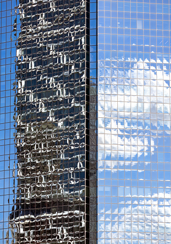 Closeup glass wall of office building with reflection of office building, abstract background with copy space, full frame vertical composition